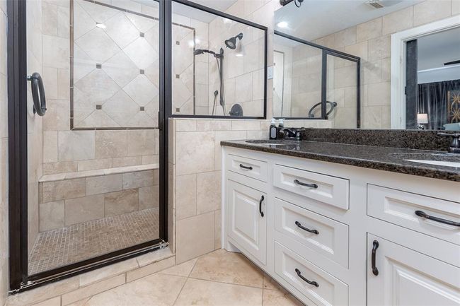 Bathroom with a shower with door, vanity, and tile patterned flooring | Image 29