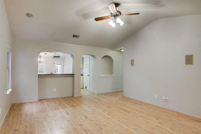 Spare room with ceiling fan, light wood-type flooring, lofted ceiling, arched walkways, and baseboards | Image 6
