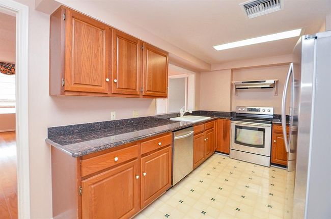 The kitchen has stainless appliances, plenty of storage and a built in desk. | Image 10