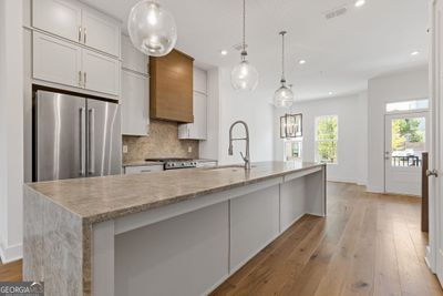 This kitchen is stunning! Waterfall quartz tops are a huge wow factor along with the matching full height backsplash! | Image 3