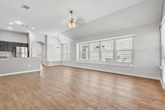 Unfurnished living room featuring a chandelier, light wood-type flooring, arched walkways, ceiling fan, and recessed lighting | Image 11