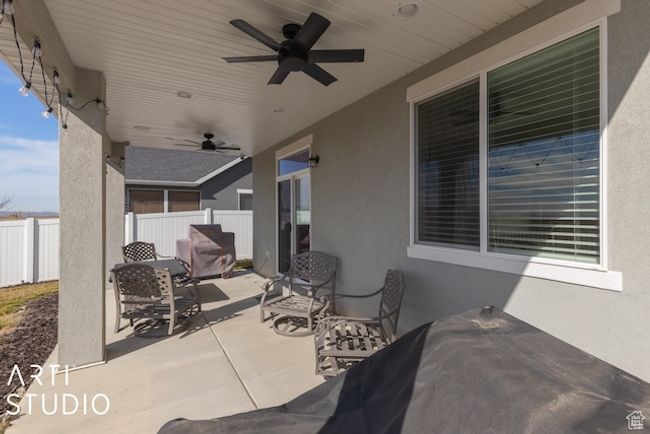 View of patio with a ceiling fan and fence | Image 42