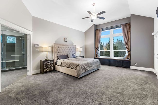 Carpeted bedroom with vaulted ceiling, ceiling fan, connected bathroom, and baseboards | Image 17