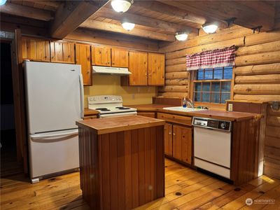 Full kitchen with storage in island and a walk in pantry to the left | Image 2