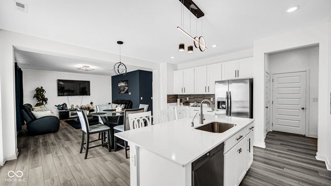 kitchen with a sink, stainless steel refrigerator with ice dispenser, dishwasher, light countertops, and light wood finished floors | Image 17