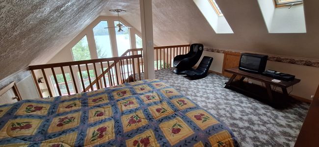 Loft area with vaulted ceiling with skylight, carpet floors, a textured ceiling, and ceiling fan | Image 30