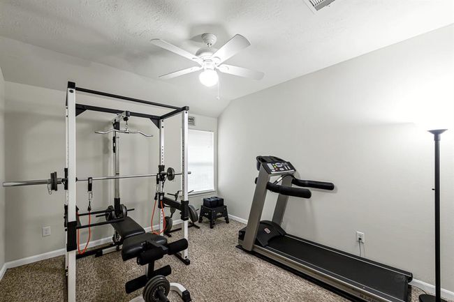 Secondary bedroom #3 with low-pile carpet and high ceiling. Currently used as home gym. | Image 17