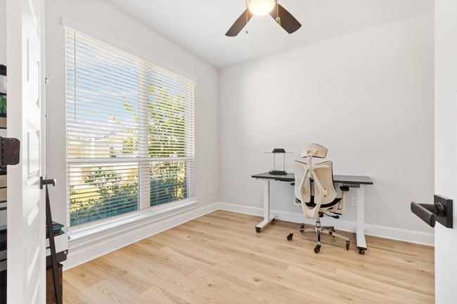 Office area featuring wood finished floors, a ceiling fan, and baseboards | Image 17