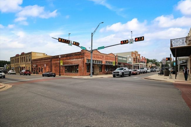 View of street featuring curbs, traffic lights, street lights, and sidewalks | Image 11