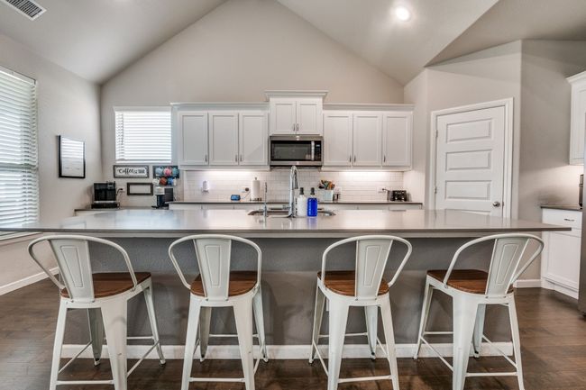 The kitchen island is perfect for breakfast or a buffet for hosting a party | Image 9