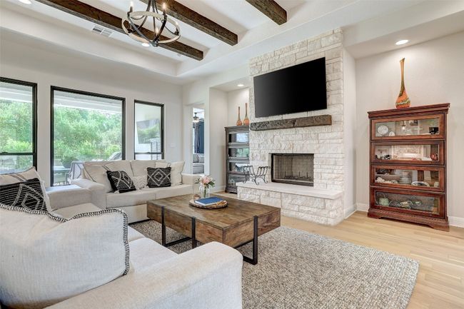 Living room with beam ceiling, wood floors, a fireplace, a chandelier, and recessed lighting | Image 5