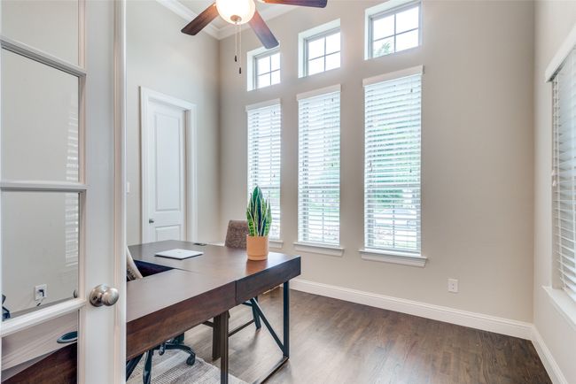 Office area with a ceiling fan, baseboards, dark wood-style floors, a towering ceiling, and crown molding | Image 5