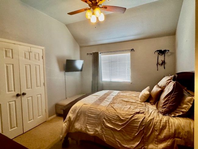 Carpeted bedroom featuring a closet, a ceiling fan, and lofted ceiling | Image 16