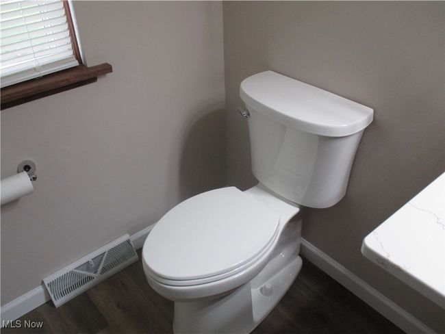 Half bath with toilet, wood finished floors, and baseboards | Image 15