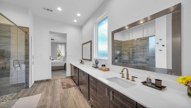 Ensuite bathroom featuring double vanity, a shower stall, wood finished floors, and recessed lighting | Image 24