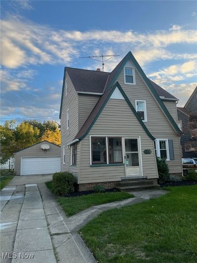 View of front facade featuring an outdoor structure, a front lawn, and a garage | Image 1