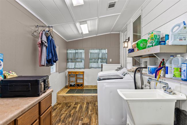 Washroom featuring dark wood-style flooring, washer and clothes dryer, and crown molding | Image 20
