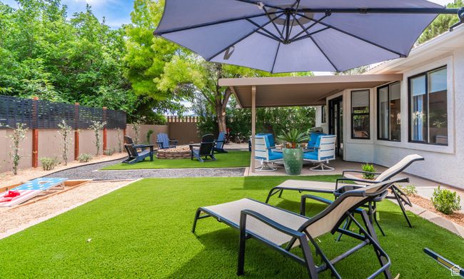 View of yard with a patio area and an outdoor fire pit | Image 25