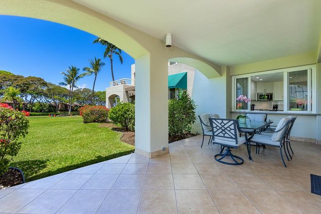 The spacious lanai offers multiple dining & lounging options with beautiful views of the palm trees | Image 28