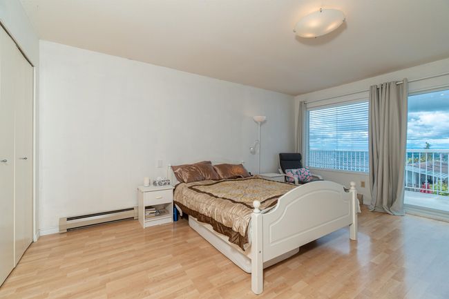 Bedroom with a baseboard heating unit, access to outside, and light wood-style floors | Image 23