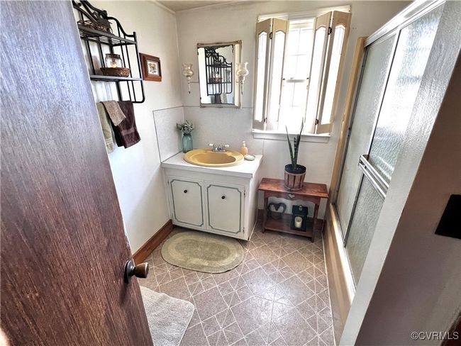 Bathroom with a shower with shower door, vanity, and tile patterned floors | Image 35