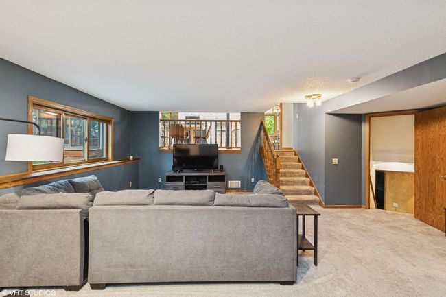 The lower level living room is open to the dining room and kitchen but also creates just the perfect amount of seperation | Image 32