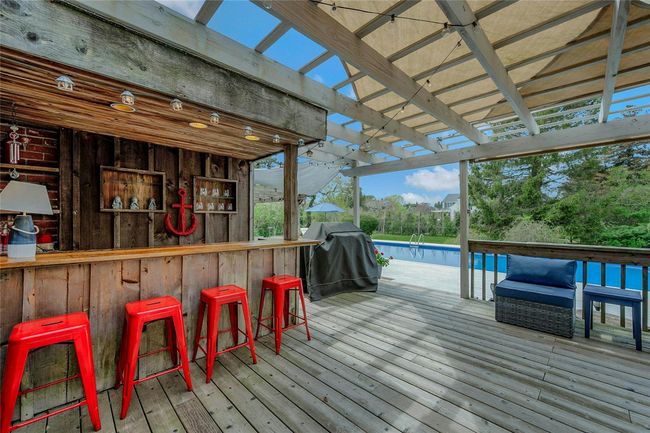 Wooden terrace featuring grilling area and an outdoor pool | Image 14