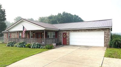 View of front of property with a front lawn, a garage, and a porch | Image 2