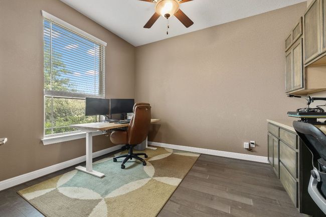 Office featuring ceiling fan, baseboards, and custom cabinets | Image 10