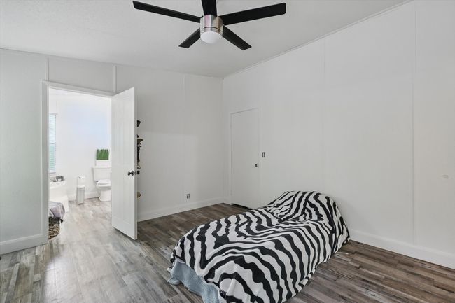 Bedroom with baseboards, a ceiling fan, wood finished floors, and ensuite bathroom | Image 11