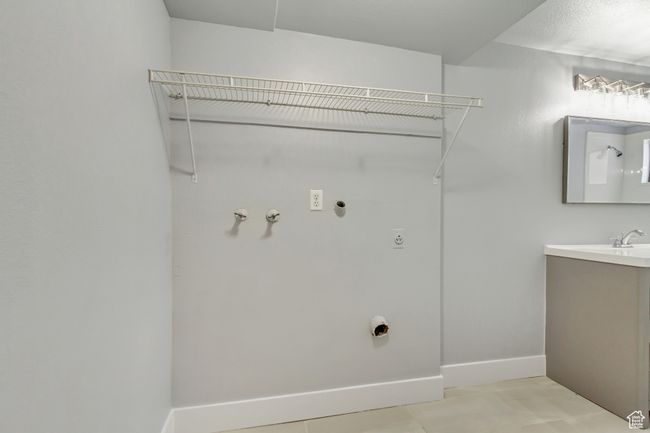 Laundry area featuring hookup for an electric dryer, baseboards, hookup for a gas dryer, and light tile patterned floors | Image 12