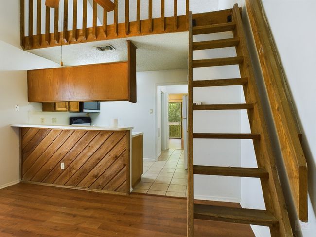 Kitchen with light wood-style flooring, brown cabinetry, baseboards, and light countertops | Image 4