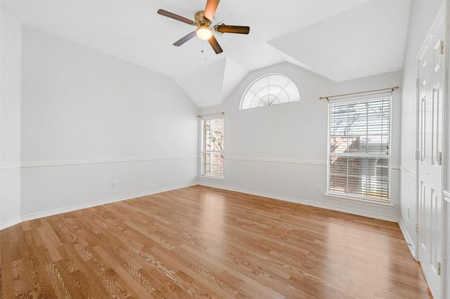 Spare room featuring a ceiling fan, light wood finished floors, and vaulted ceiling | Image 21