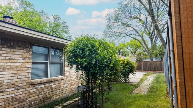View of home's exterior with fence, a patio, and a chimney | Image 12