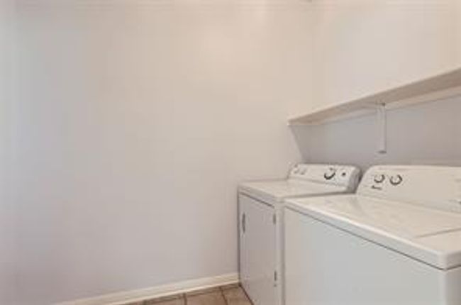 Washroom featuring washer and dryer and light tile patterned floors | Image 24