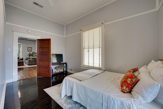 Bedroom with multiple windows, hardwood / wood-style floors, visible vents, and ornamental molding | Image 16