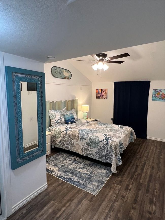 Bedroom with baseboards, a textured ceiling, wood finished floors, and ceiling fan | Image 25