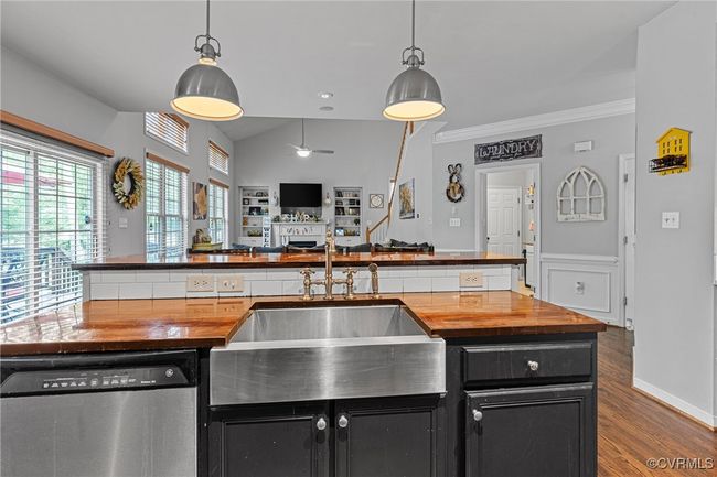 Kitchen featuring a sink, wood counters, stainless steel dishwasher, and dark cabinetry | Image 11