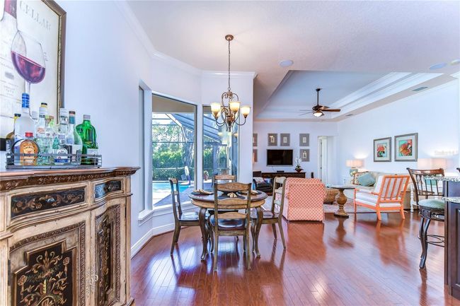 The seamless flow of the hardwood floors guides you from a cozy dining area to an inviting living space, perfect for entertaining guests. | Image 14