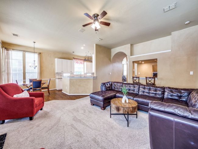 Living room featuring ceiling fan, carpet floors, arched walkways, and a chandelier | Image 10