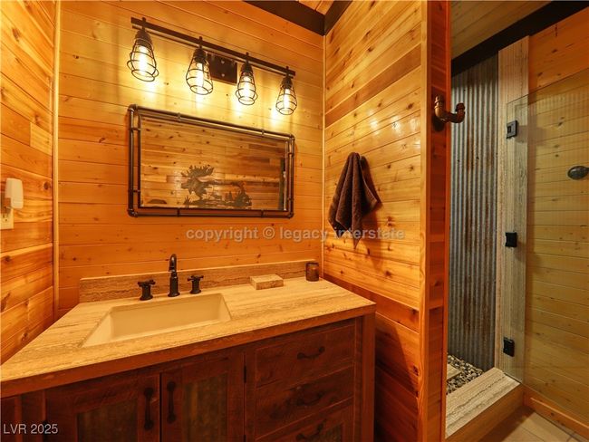 Full bath with vanity, a stall shower, and wooden walls | Image 20