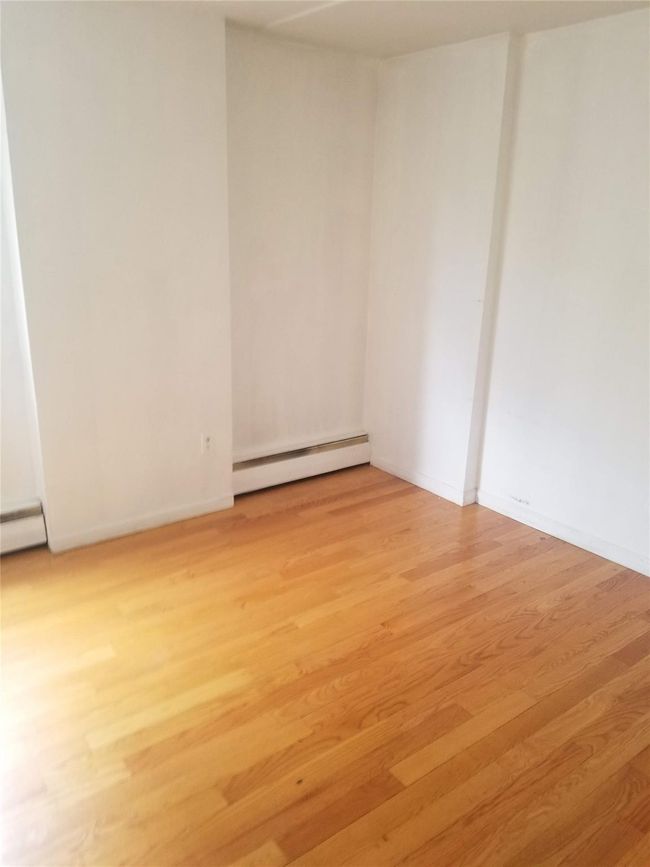 Spare room featuring a baseboard heating unit, light wood finished floors, and baseboards | Image 4