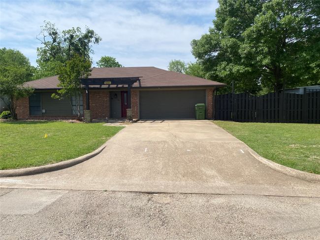 Ranch-style home with fence, driveway, a front yard, and a garage | Image 25