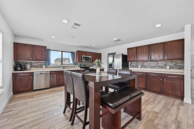 Kitchen featuring stainless steel appliances, backsplash, a sink, light wood-type flooring, and recessed lighting | Image 14