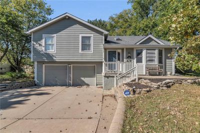 Tri-level home featuring a garage and a porch | Image 1