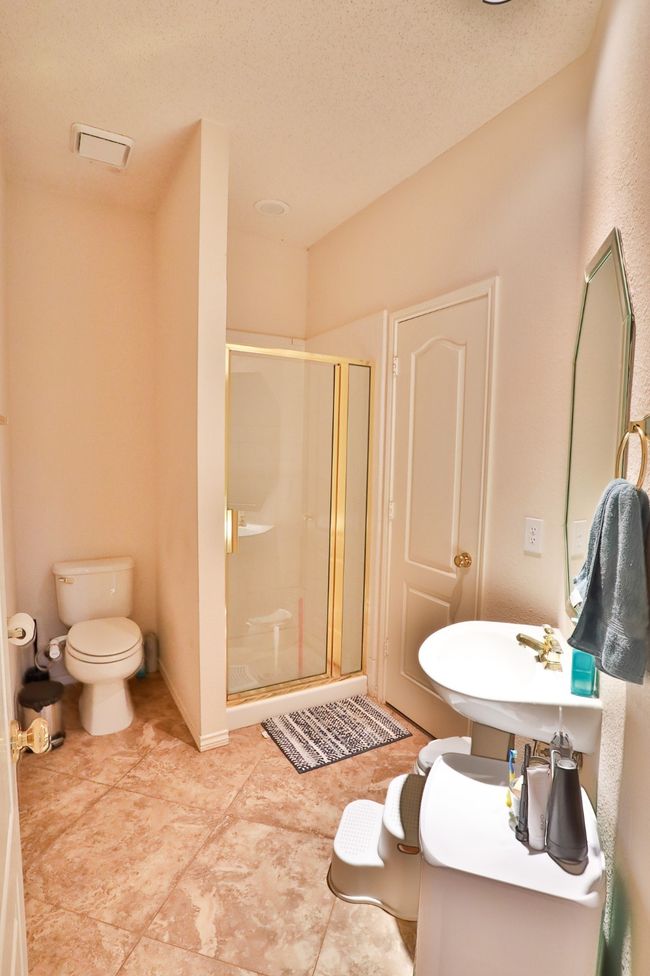 Bathroom with a shower stall, a textured ceiling, and tile patterned floors | Image 22