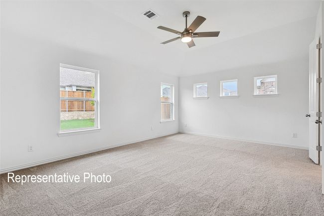 Carpeted spare room featuring ceiling fan, a wealth of natural light, visible vents, and baseboards | Image 8