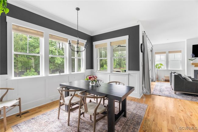 Dining room featuring a chandelier, a decorative wall, a wainscoted wall, and light wood finished floors | Image 16