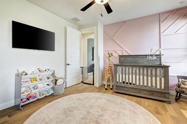 Bedroom with wood finished floors and ceiling fan | Image 24