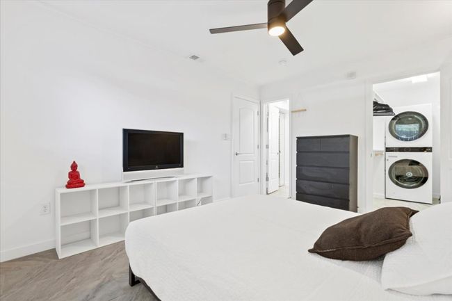 Bedroom featuring estacked washer and dryer and a ceiling fan | Image 15